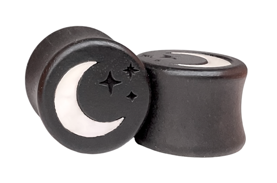 A pair of black wooden ear plugs with a crescent moon design inlaid from mother of pearl, accompanied by star details.