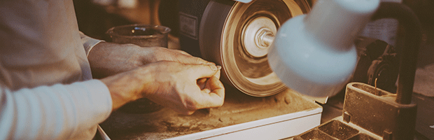 Wet sanding jewelry on a buffing wheel.