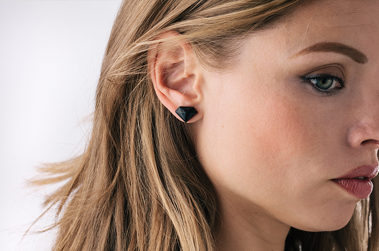 Side headshot of female wearing a black wood earring.
