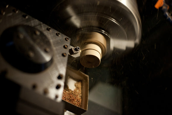 CNC lathe carving a wood ear gauge plug.  