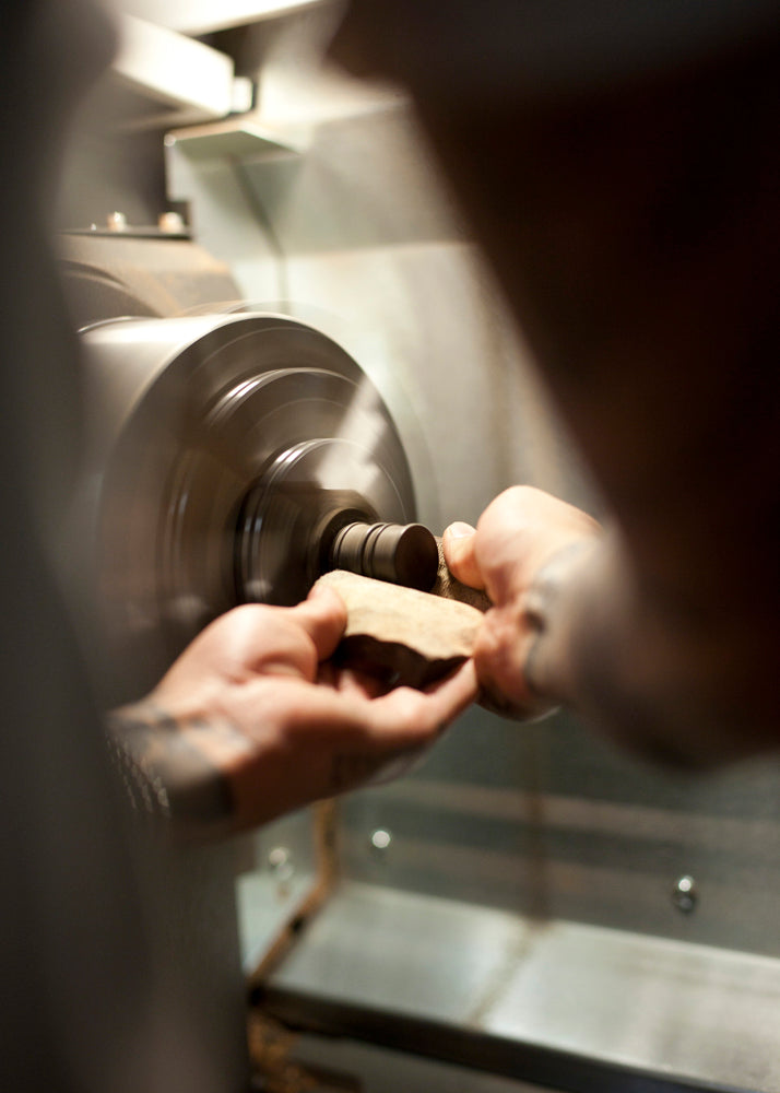 Hand sanding wood ear gauge plugs on CNC lathe. 