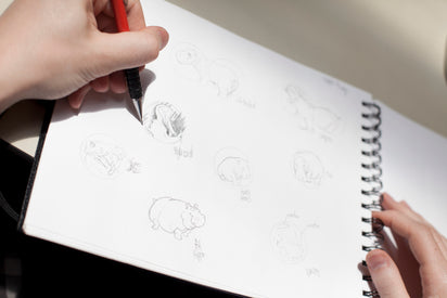 Hand sketching custom ear gauge designs. 