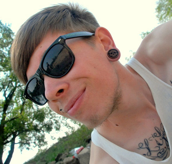 Customer wearing Day of the Dead wood ear gauges. 