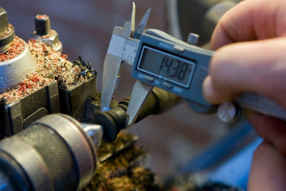 Calipers measuring wood ear gauges on lathe. 