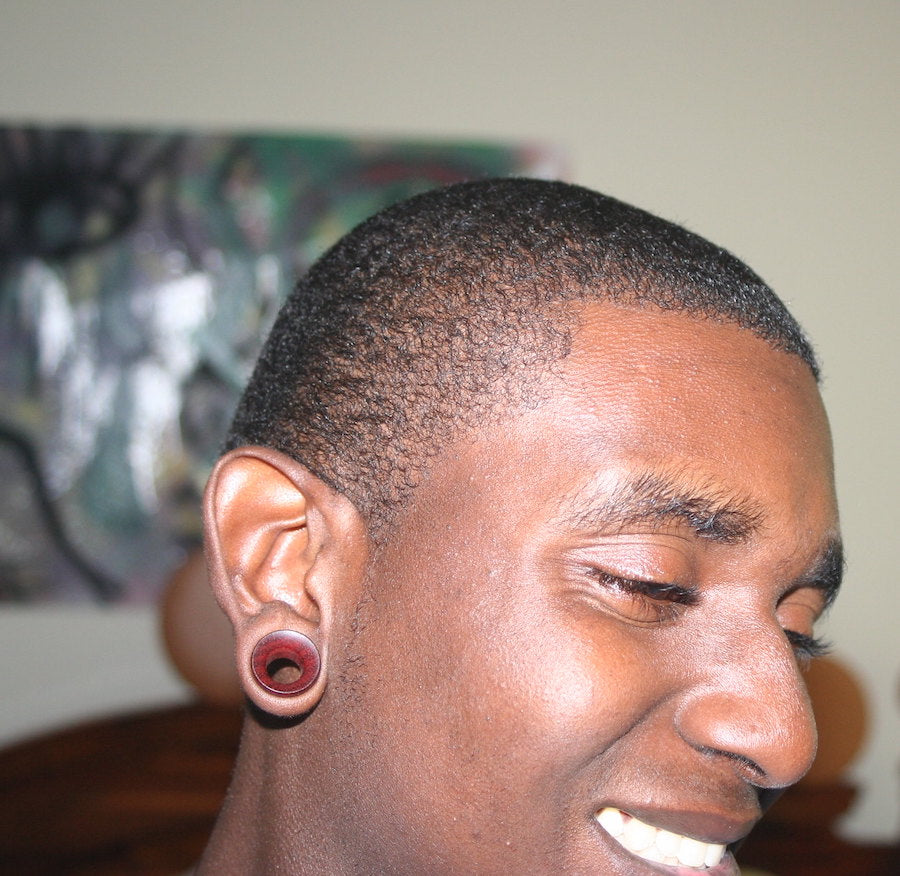 Customer wearing a pair of Omerica Organic Bloodwood Tunnel plugs. 