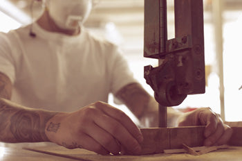 Cutting through wood stock on large band saw.