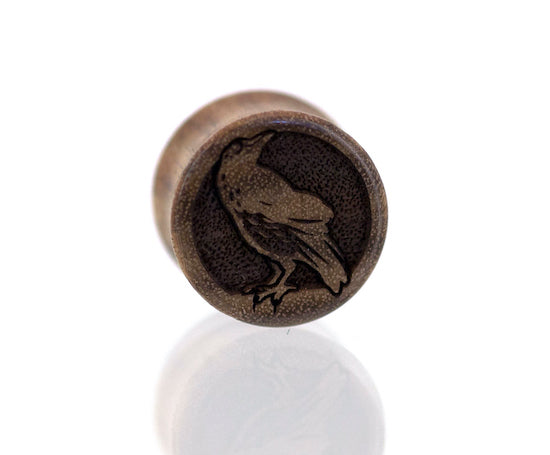 Ear gauge plugs in Chechen wood with Nevermore Raven etched graphic. 