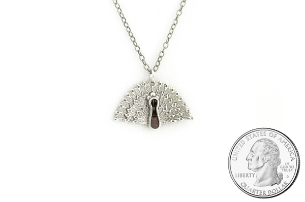 Peacock pendant made in sterling silver with blue mahoe wood inlay. Size scale. 